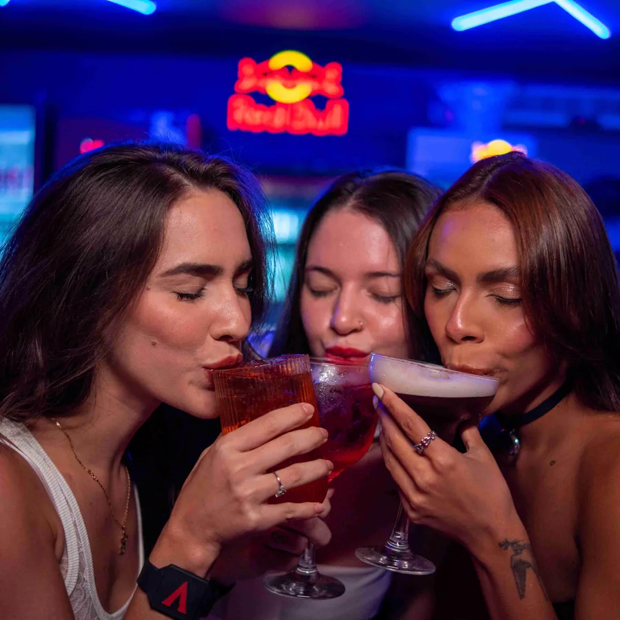 Três pessoas brindam com drinques em uma ação da Viciu.